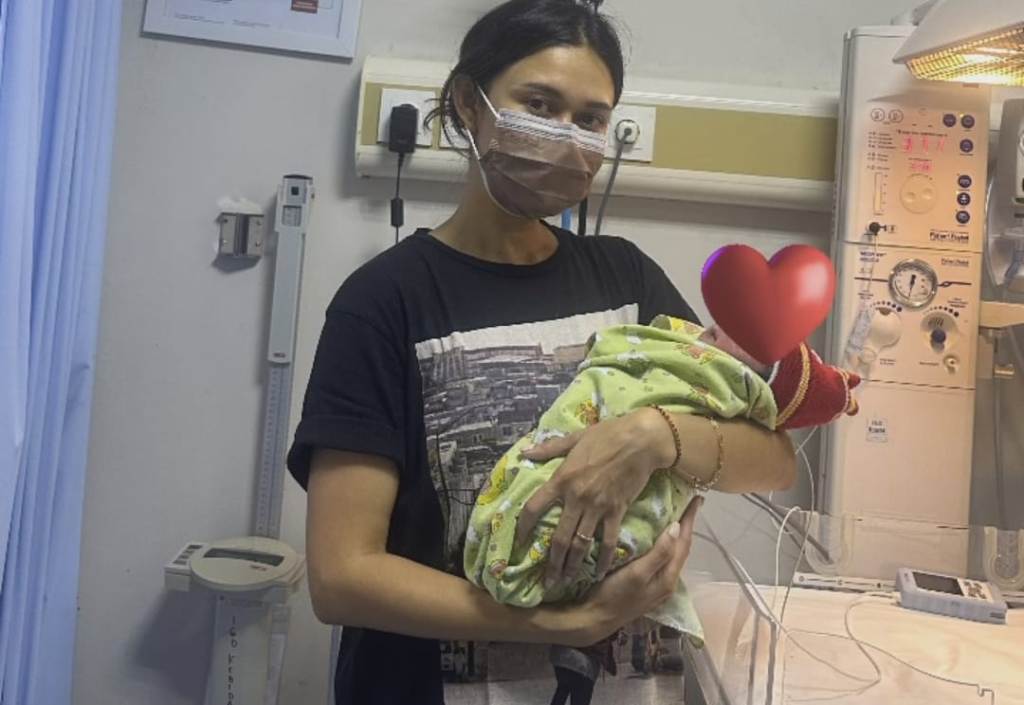 GENDONG: Artis cantik Nana Mirdad menggendong bayi yang sebelumnya ditemukan di semak-semak di dekat rumahnya di Bali
