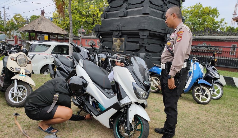 Pemilik kendaraan dengan knalpot brong sedang mengganti knalpot di lapangan Polres Buleleng,  Selasa, 23 Januari 2024.