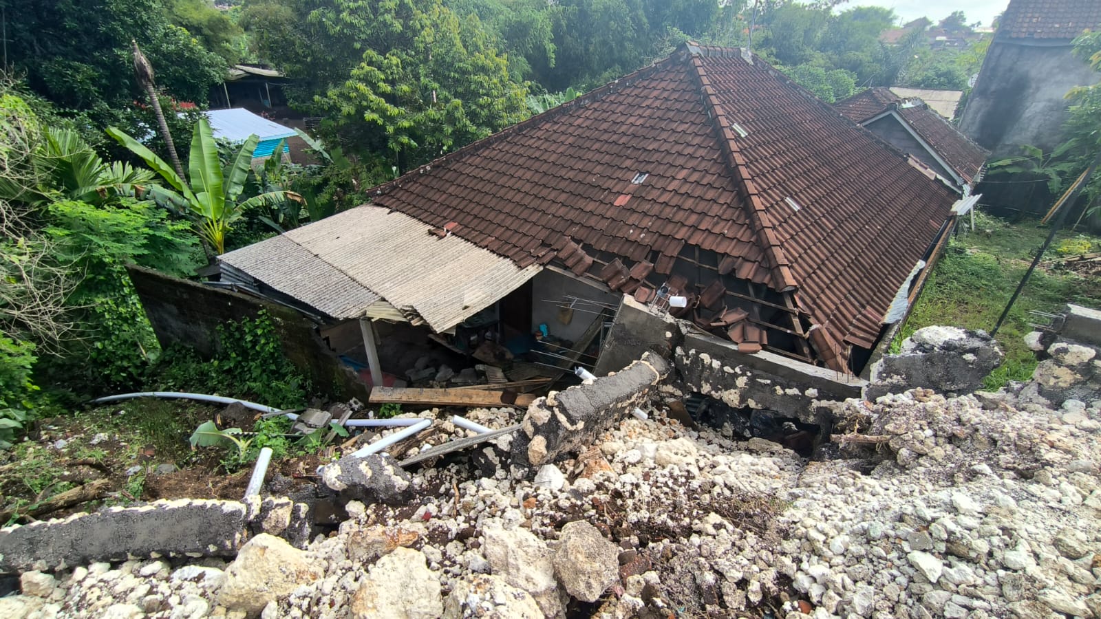 Hujan deras di Kota Denpasar mengakibatkan senderan jebol dan menimpa rumah warga, Sabtu, 27 Januari 2024.