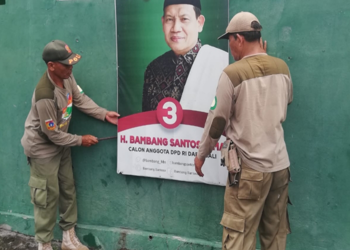 DITURUNKAN: Satpol PP Karangasem menurunkan APK yang ada di Kabupaten Karangasem, Senin (12/2).