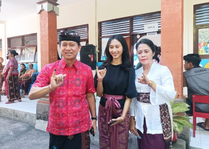 MENCOBLOS : Mantan Bupati Klungkung I Nyoman Suwirta bersama istri dan anaknya saat mencoblos di TPS 8, Rabu (14/2).