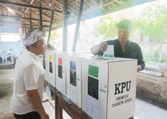 NYOBLOS : Ketua DPC PDIP Klungkung sekaligus Ketua DPRD Klungkung Anak Agung Gde Anom saat mencoblos di TPS 06 Banjar Mergan, Rabu (14/2).
