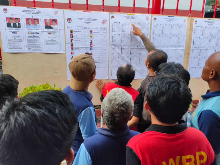 Warga binaan sedang mengamati papan informasi terkait caleg-caleg yang akan dipilih