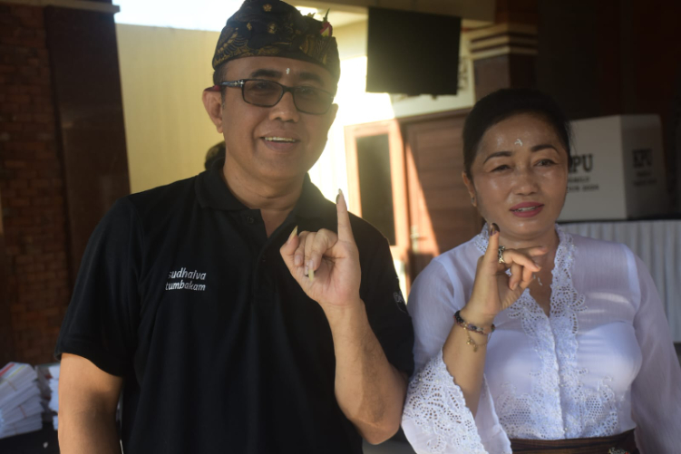 Walikota Denpasar, I Gusti Ngurah Jaya Negara bersama istri saat mencoblos di TPS 17 Banjar Saba Penatih, Denpasar Timur, Rabu 14 Februari 2024.