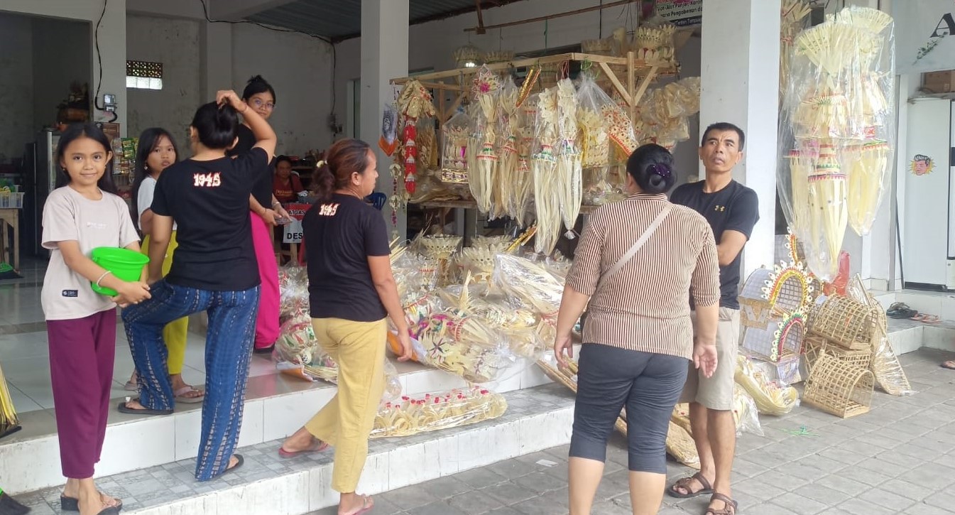 Pedagang hiasan penjor Galungan di Jalan Teuku Umar, Lingkungan Tampuagan, Kabupaten Karangasem, Bali memberikan doorprize kepada pelanggan, Senin, 26 Februari 2024.