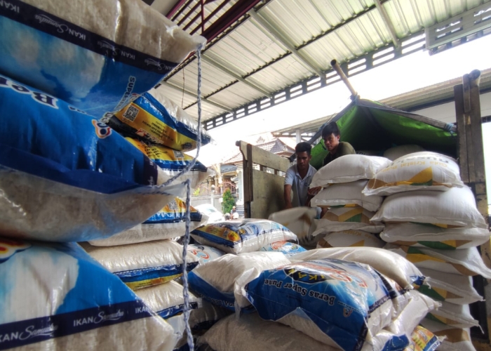 TURUN : Aktifitas buruh menurunkan beras di Pasar Klungkung.