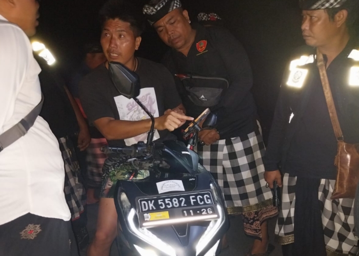 BERULAH : Seorang bule Jepang dihentikan Pecalang saat melintas menggunakan sepeda motor pada Hari Raya Nyepi, Senin (11/3).