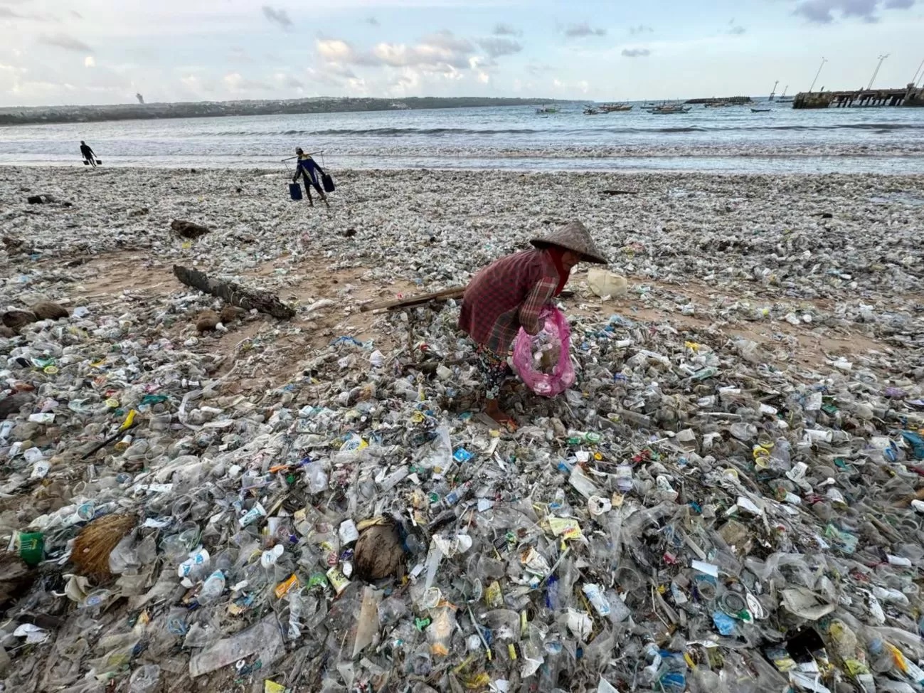 LAUTAN SAMPAH: Beberapa pemulung tampak mengais di lautan sampah plastik Pantai Kedonganan Jimbaran Badung Bali, 19 Maret 2024. (adrian suwanto/radarbali.id)