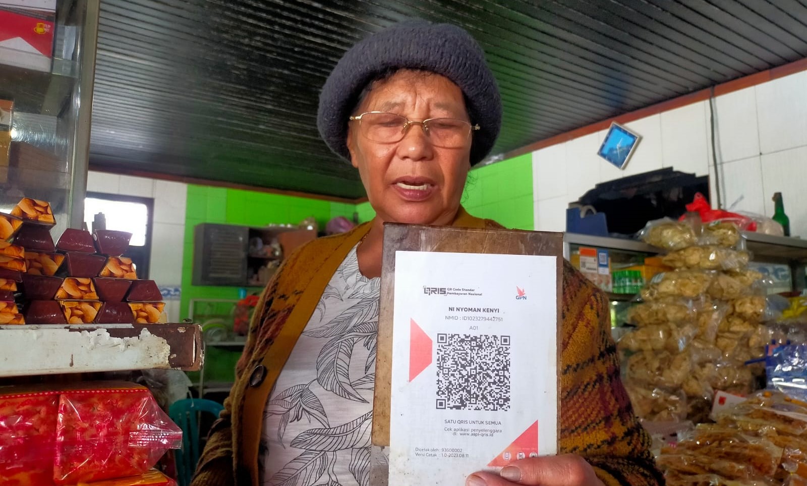 Ni Nyoman Kenyi, pemilik warung makan di seberang Pura Puncak Penulisan, Kabupaten Bangl, Bali menunjukkan QRIS BRI,  Minggu, 10 Maret 2024.