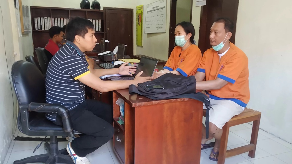 INTEROGASI: I Putu Arya Setiawan dan istrinya, Citra Pujianti, menjalani pemeriksaan di ruang Unit Reskrim Polsek Kalibaru Jumat (22/3). (Gareta)