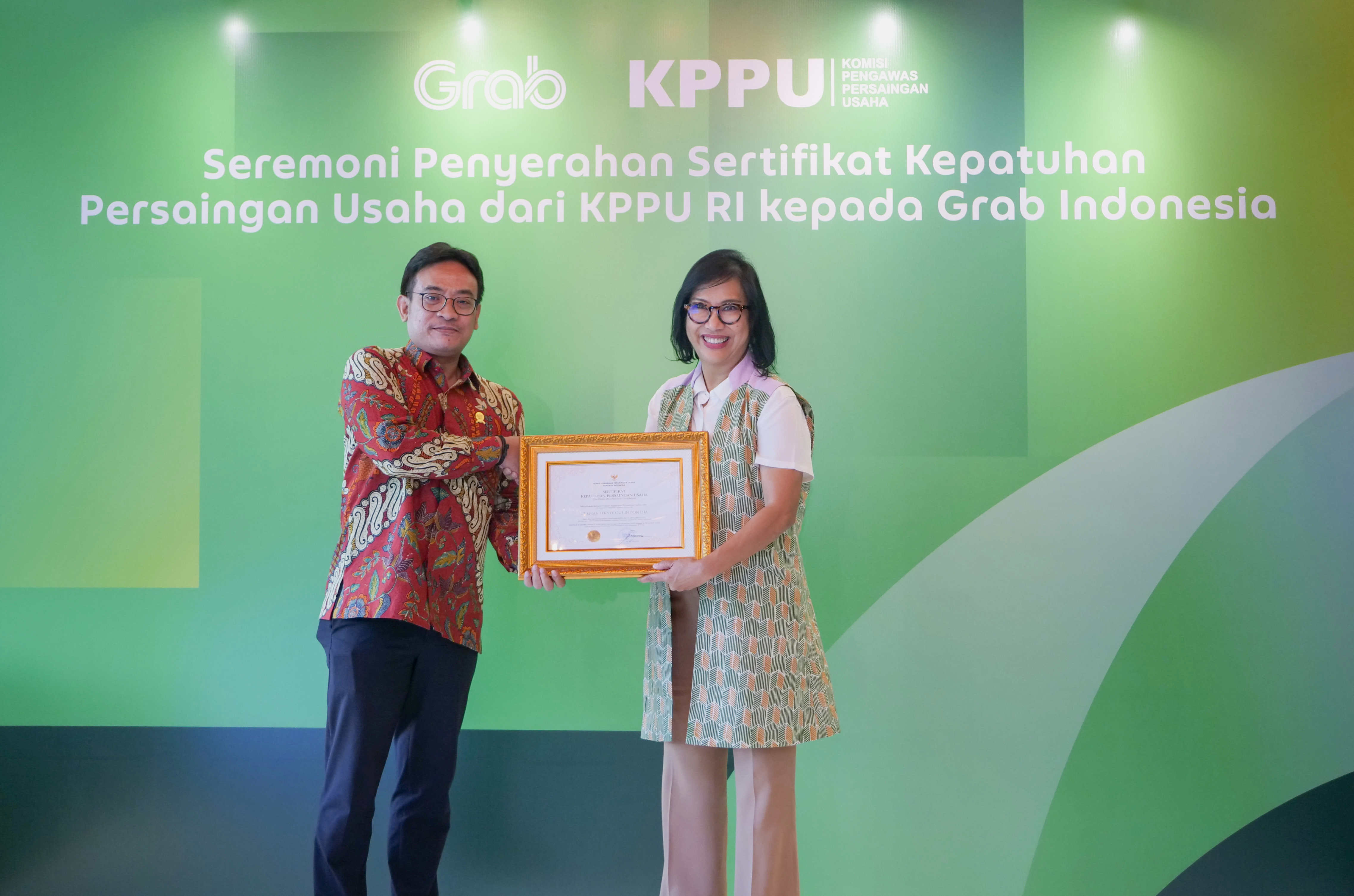 Wakil Ketua KPPU RI Aru Armando memberikan sertifikat kepada Country Managing Director, Grab Indonesia, Neneng Goenadi di Jakarta pada Senin (25/3) .(Foto ist)