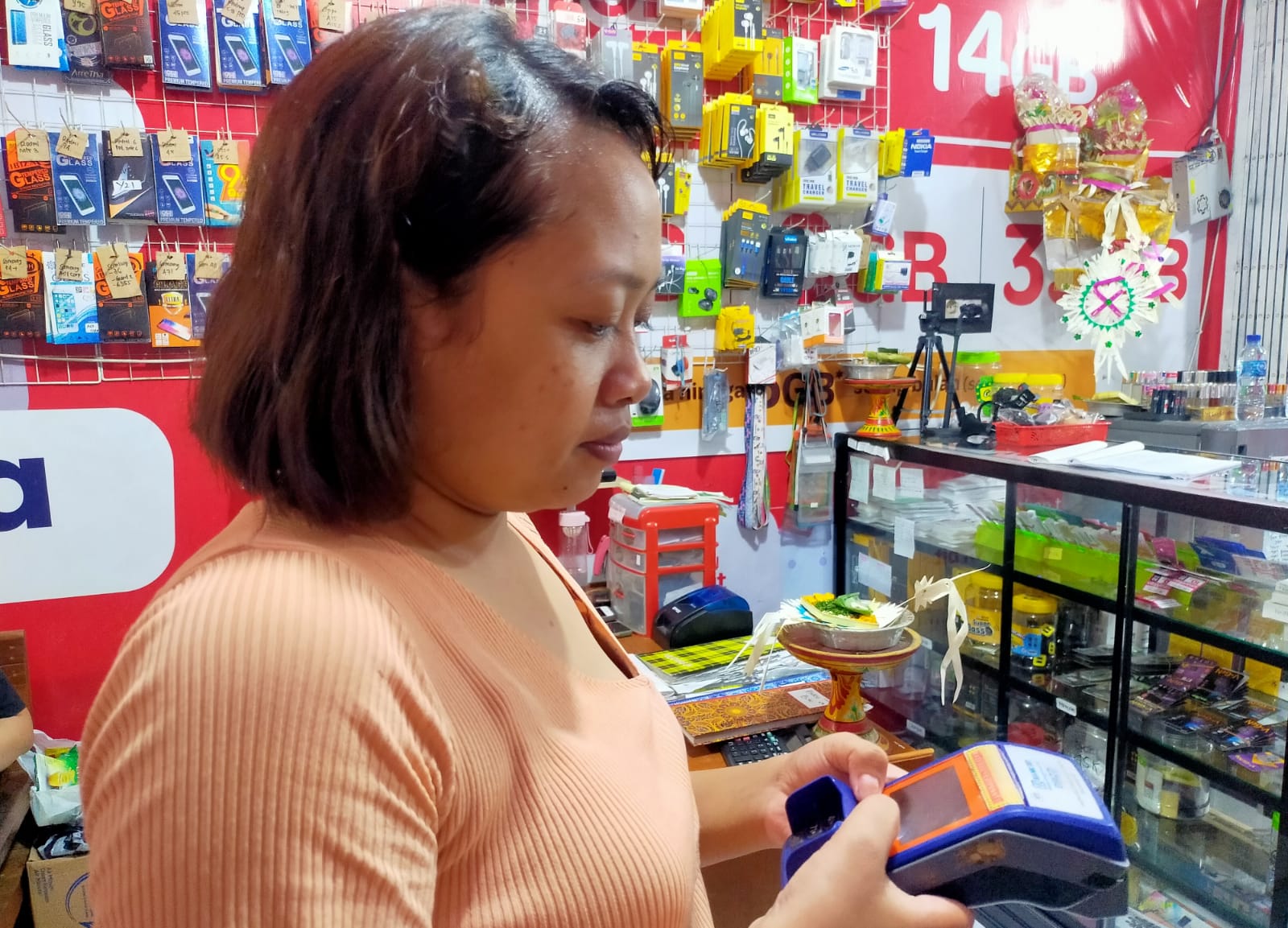 Agen BRILink di Kota Bangli, Bali Ni Kadek Muliani menunjukkan mesin EDC yang biasa dipakai transaksi perbankan, Sabtu, 9 Maret 2024.