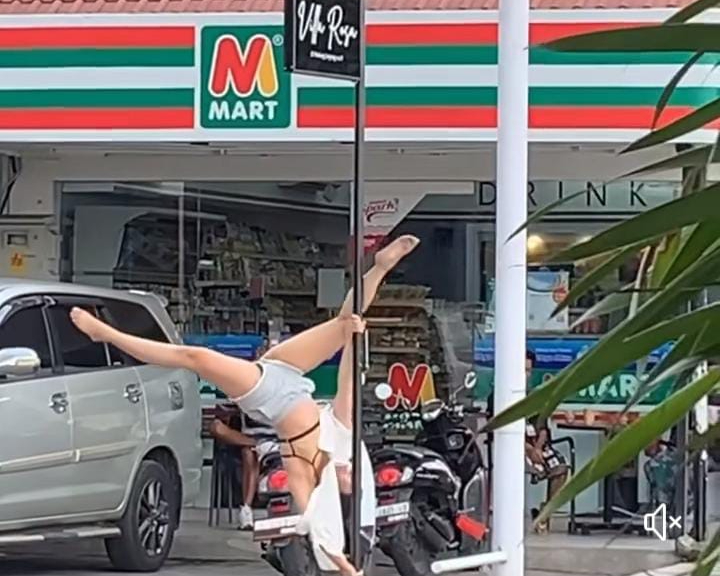 Bule melakukan pole dance dengan tiang dipinggir jalan
