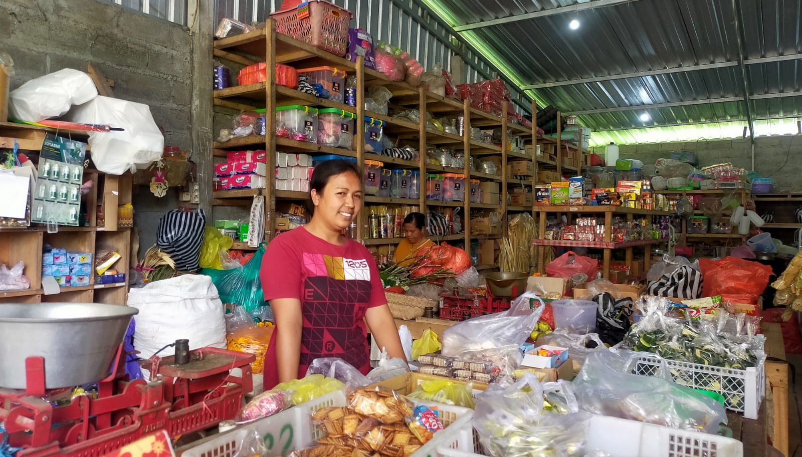 Ni Wayan Wirawati, pemilik warung kelontong di Jalan Nusantara, Kelurahan Kubu, Kabupaten Bangli, Bali di sela-sela melayani pembeli, Jumat, 22 Maret 2024.