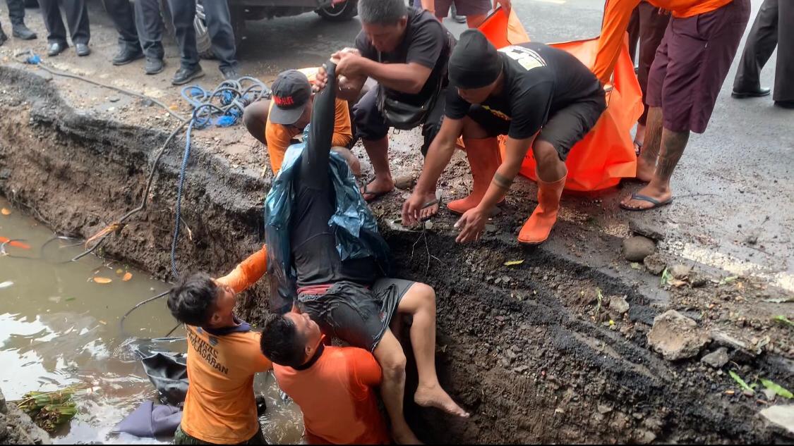 Petugas melakukan evakuasi korban yang terjatuh di proyek drainase di Gianyar, Bali.