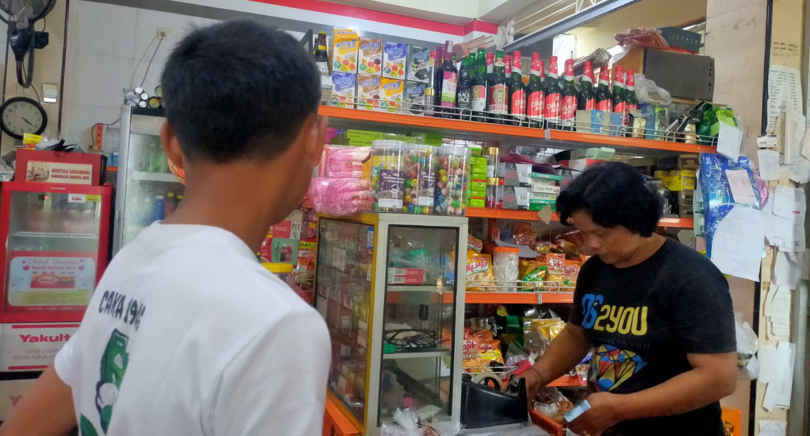 Ni Nyoman Ariani (kanan), pelaku UMKM nasabah BRI di Kabupaten Bangli, Bali melayani pembeli, Senin, 1 April 2024.