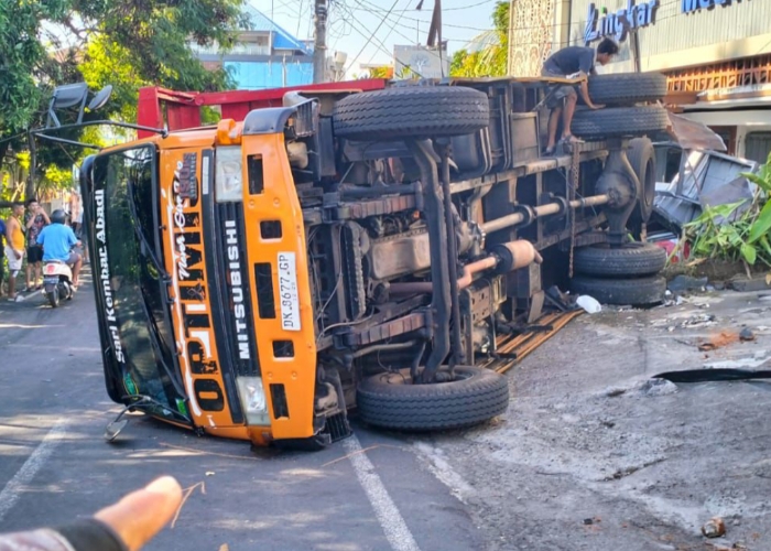 RUSAK: Truk terguling usai menabrak klinik, laundry dan beberapa kendaraan akibat gagal menanjak.