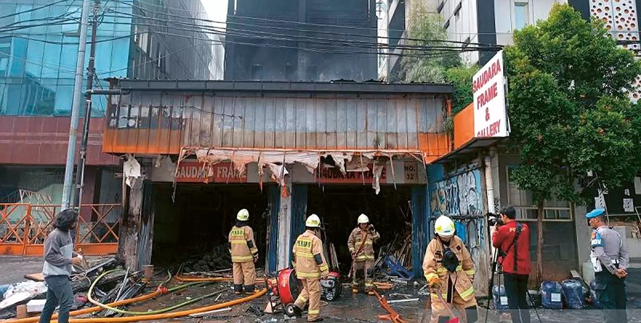 INSIDEN MAUT: Petugas melakukan pendinginan di ruko yang terbakar di Mampang Prapatan, Jakarta Seatan, Jumat (19/4). (ANTARA)