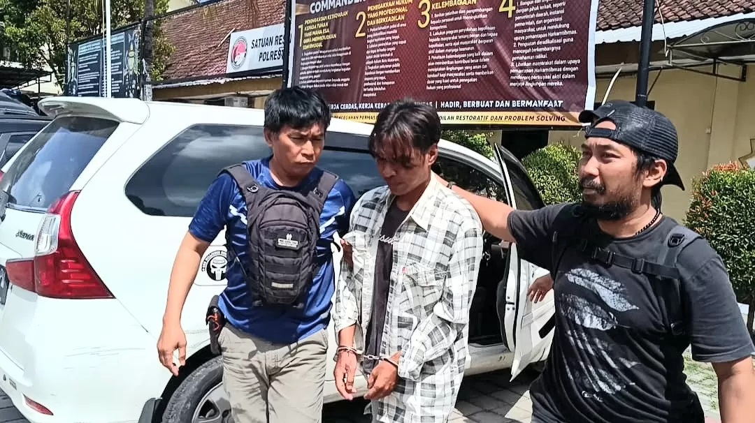 Komang Astika (tengah), pria yang menikam mantan istrinya hingga tewas menyerahkan diri ke Polsek Sandubaya dan dibawa ke Polresta Mataram, Senin (22/4). (Toni/Lombok Post)