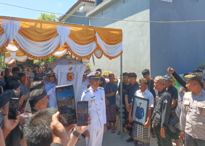 PENYERAHAN : Jenazah almarhum Putu Satria Ananta Rustika diupacarai secara dinas sebelum dibawa ke Setra Desa Adat Gunaksa menggunakan Bade, Jumat (10/5).