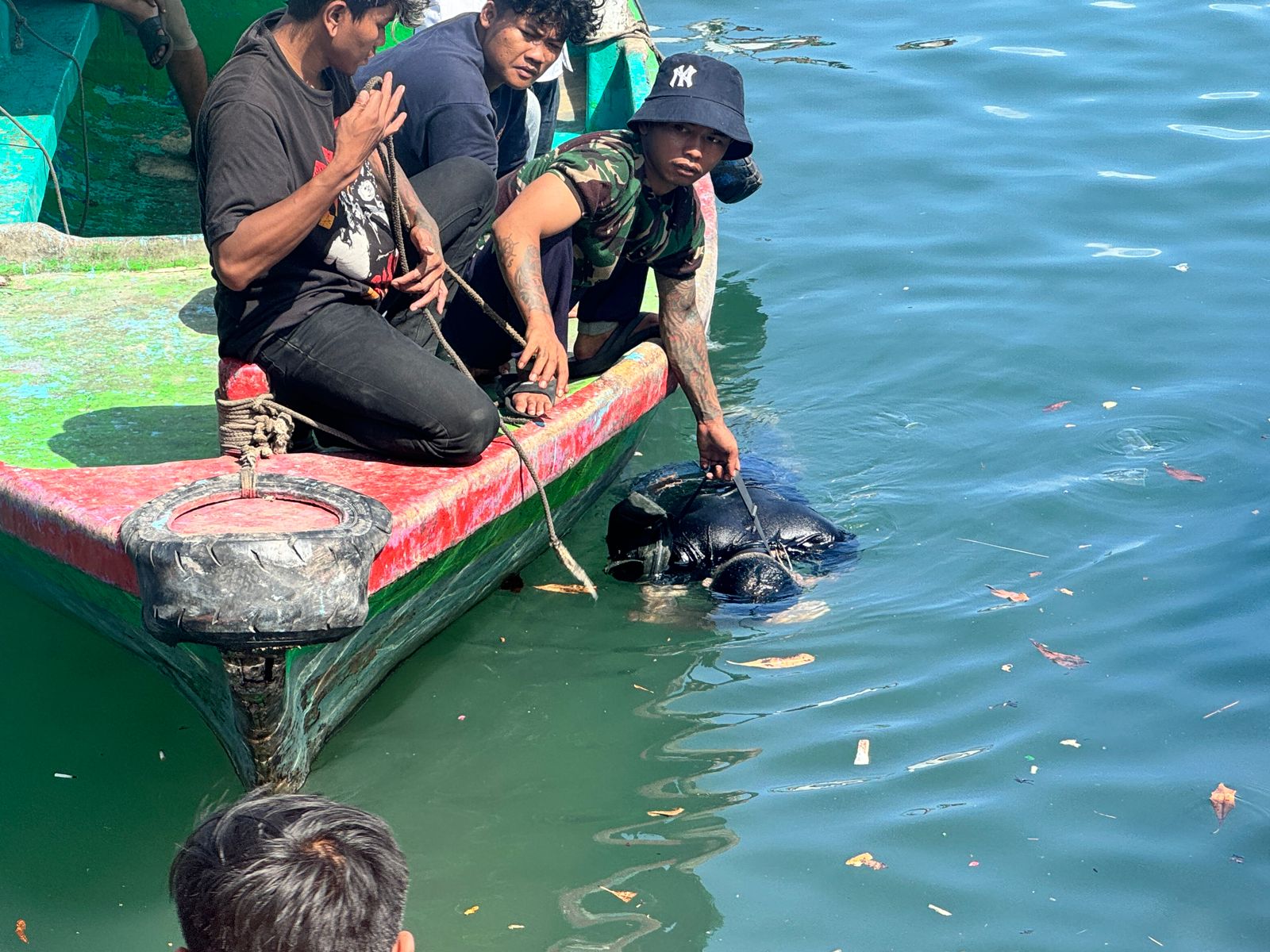EVAKUASI: Rekan-rekan ABK mengevakuasi mayat korban yang mengapung di Perairan Kolam Bandar Dermaga Barat Pelabuhan Benoa.