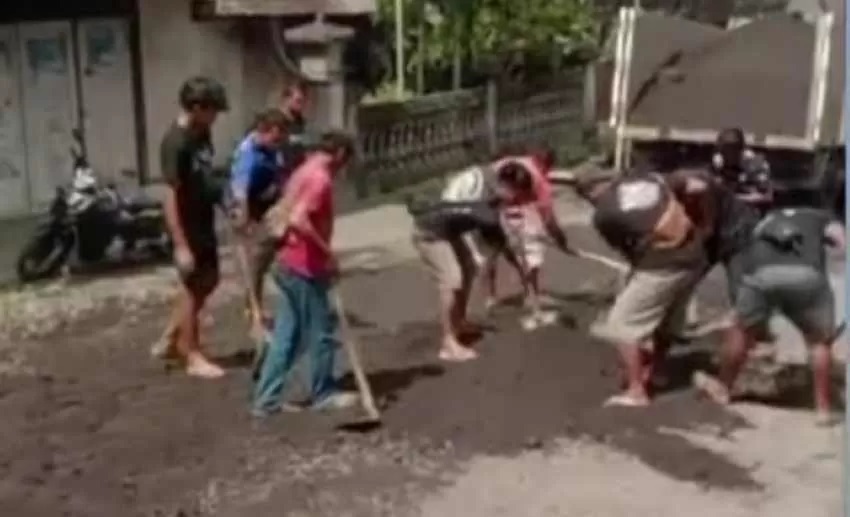 GOTONG ROYONG BERSAMA : Aksi sopir truk saat melakukan perbaikan secara gotong royong jalan di wilayah Selat yang mengalami kerusakan parah. (foto:Istimewa)