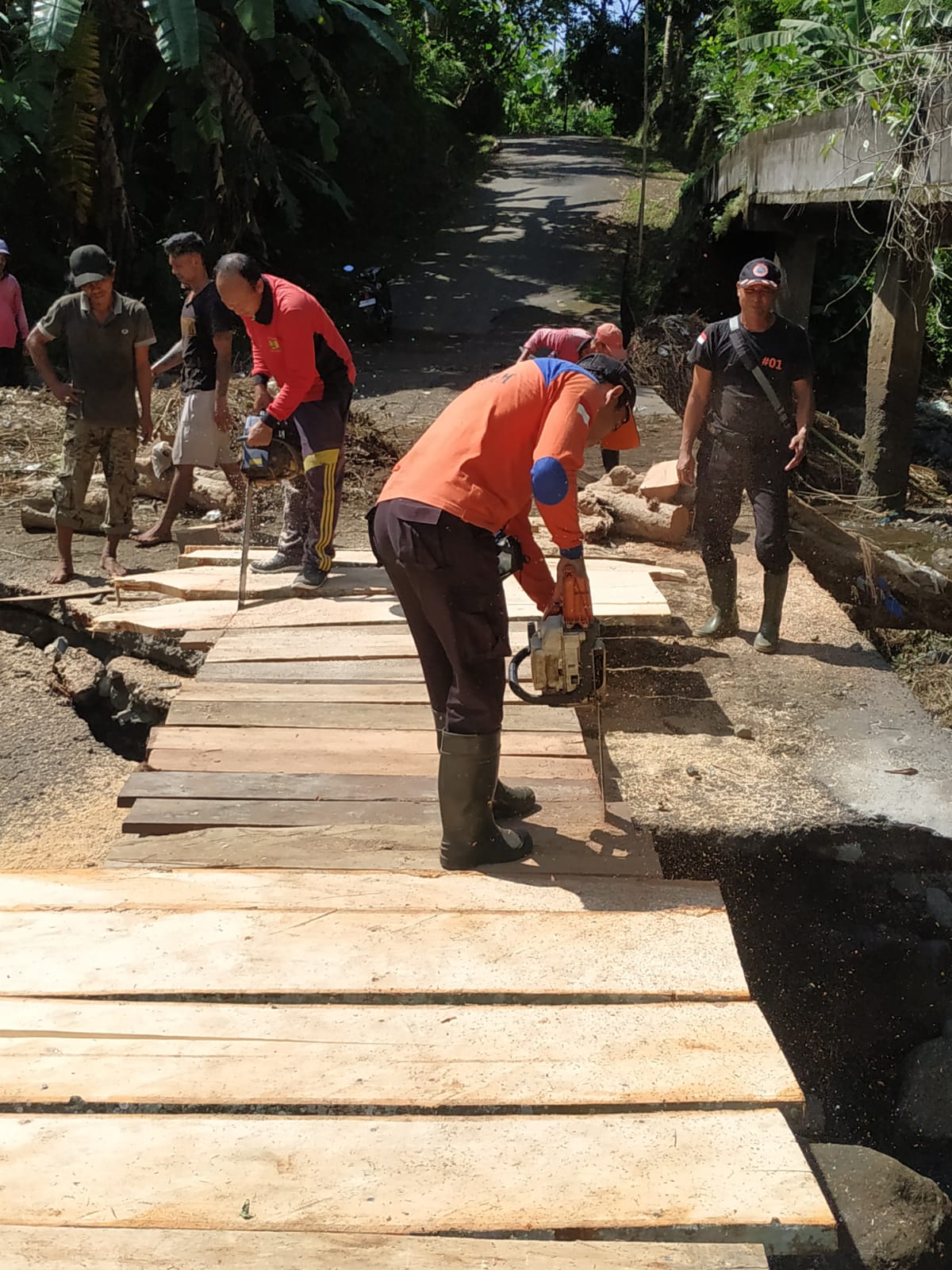 GOTONG ROYONG: Warga di Banjar Dinas Belong, Desa Manggis, Kecamatan Manggis melakukan gotong royong dibantu BPBD dan Dinas PUPR Karangasem membuat jembatan darurat dari batang kelapa.