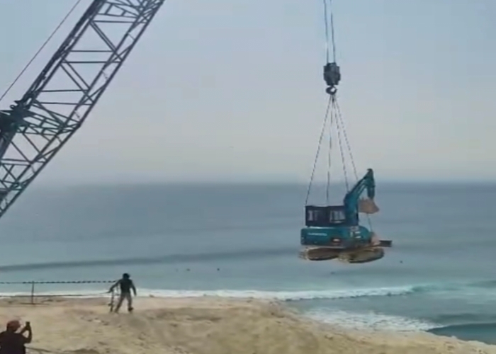 PEMBERSIHAN: Penurunan alat berat ke Pantai Pemutih, Desa Pecatu, Kuta Selatan untuk pembersihan retuthan batu kapur, Sabtu (15/6).