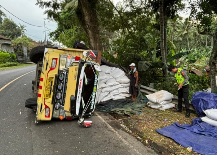 TERGULING: Sebuah truk bermuatan kopi dan sepeda motor terguling di Banjar Dinas Tengading, Desa Antiga, Kecamatan Manggis, Kabupaten Karangasem pada Senin (17/6).