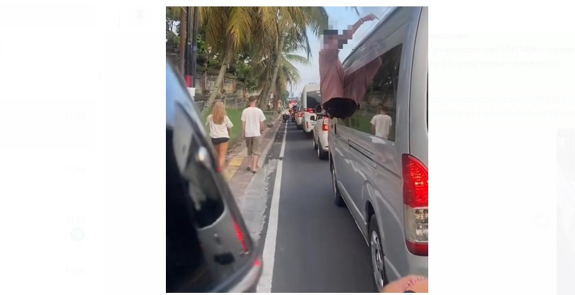 Seorang Bule terlihat mengeluarkan setengah badan dari jendela mobil yang tengah melaju di Kawasan Ubud Bali