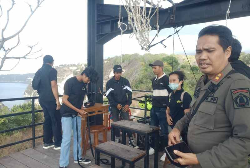 Satpol PP Klungkung saat menutup wahana wisata flying fox di Pantai Diamond, Nusa Penida, Kabupaten Klungkung, Bali, Jumat (12/7/2024).