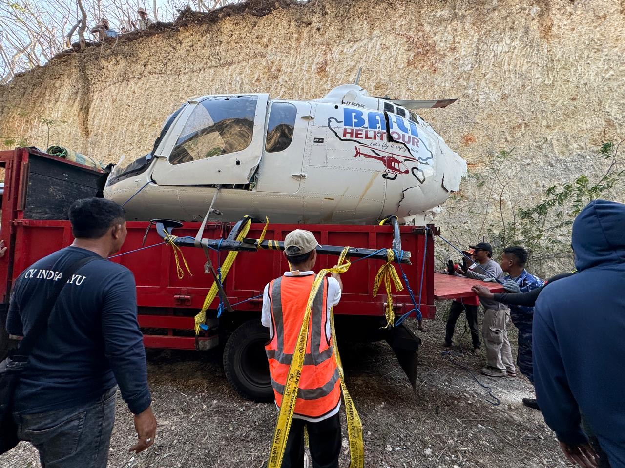 EVAKUASI: Evakuasi helikopter yang terjatuh di kawasan tebing Pantai Suluban, Desa Pecatu, Kuta Selatan, Minggu (21/7).