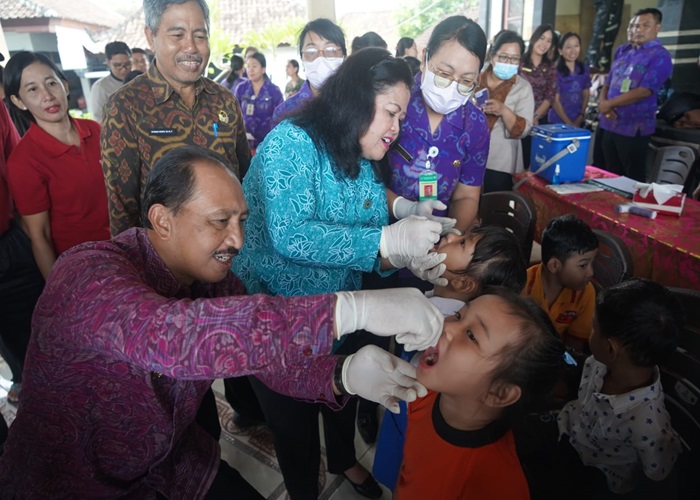 TINJAU : Pj Bupati Jendrika saat meninjau pelaksanaan PIN Polio di Bale Banjar Desa Takmung, Selasa (23/7/2024).