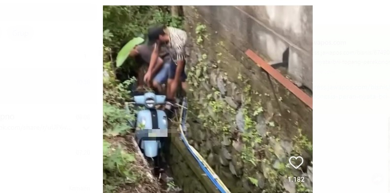 Proses evakuasi sepeda motor yang nyemplung ke got di jalanan Bali