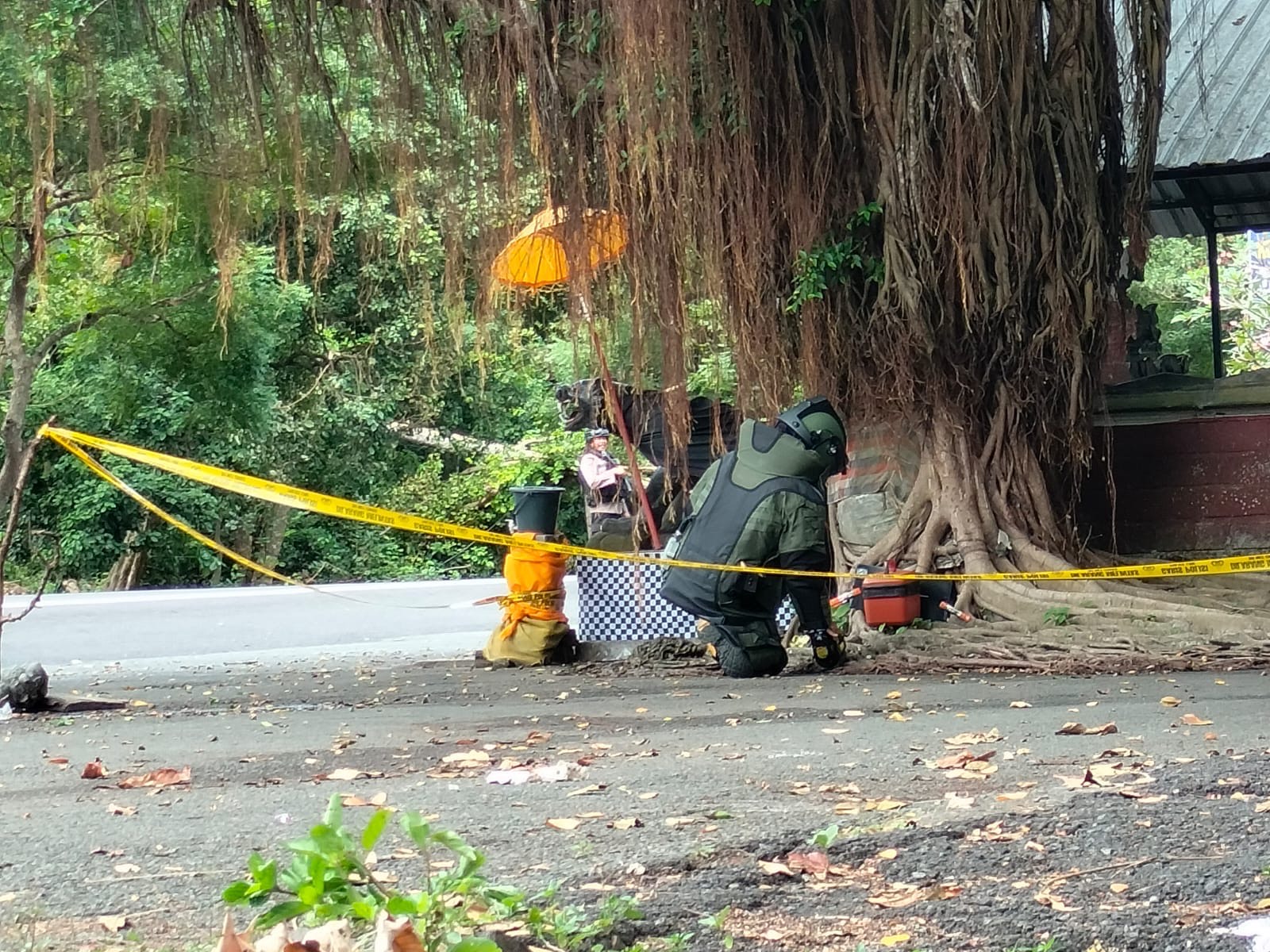 KOTAK: Tim Jibom Detasemen C Pelopor Brimob Polda Bali memeriksa isi kotak misterius yang dibawa seorang laki-laki di Pura Tirta Segara Rupek.
