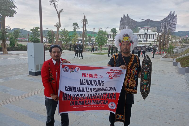 Warga Sampit Kalimantan Tengah Wahyudi (kiri) bersama dengan pekerja kemenko 1 IKN Dewo di depan Istana Negara IKN, Sabtu (17/8/2024).