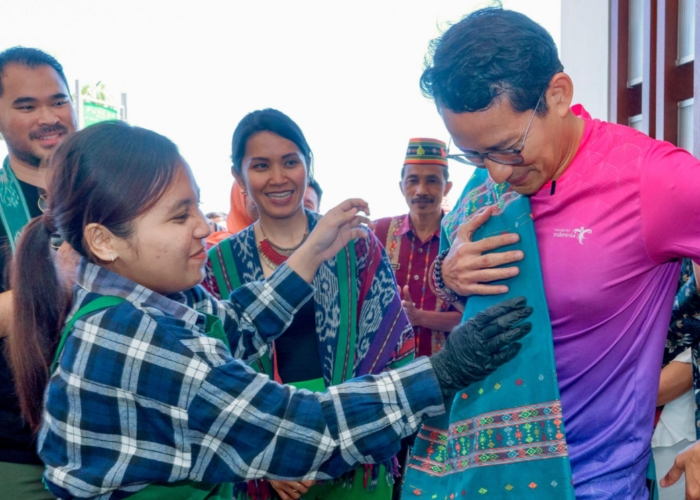 Tirza Munusamy, Chief of Public Affairs, Grab Indonesia (tengah) mendampingi Sandiaga Uno, Menteri Pariwisata dan Ekonomi Kreatif Republik Indonesia (kanan) saat mengenakan kain tradisional.