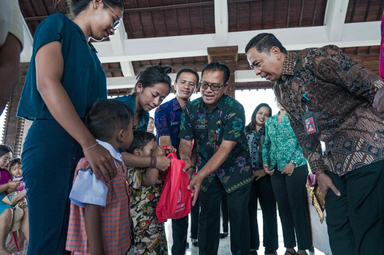 Kadis Perikanan Badung I Nyoman Suardana saat memberikan paket olahannikan kepada masyarakat di Desa Baha, Kecamatan Mengwi, Selasa (27/8).