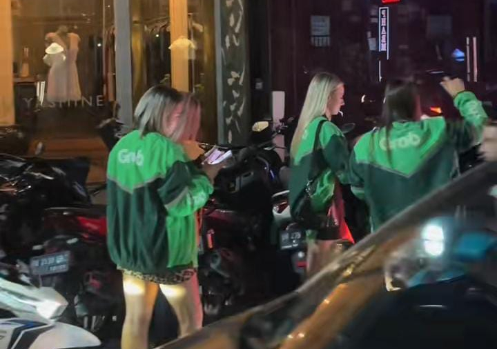Sejumlah bule wanita terlihat jalan-jalan menggunakan jaket ojol