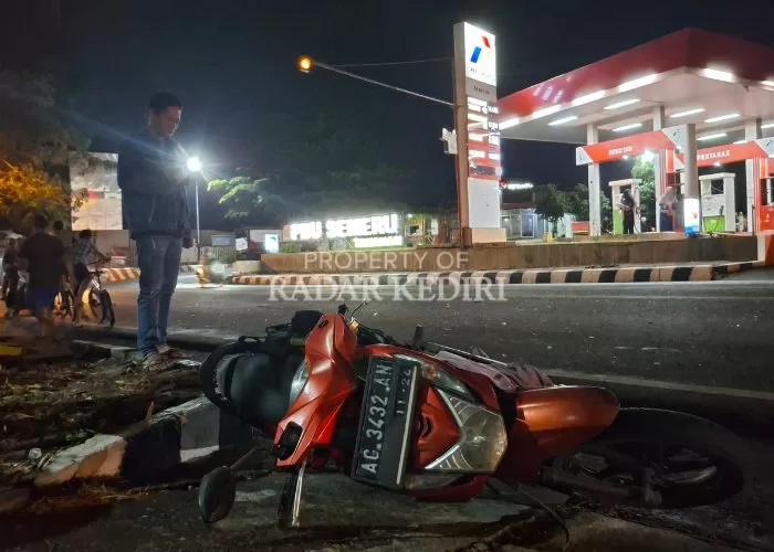 PILU: Sepeda motor Honda Beat yang dikendarai korban tergeletak di pinggir jalan raya Semeru Kelurahan Tamanan, Kota Kediri usai tabrakan dengan bus Harapan Jaya. (FOTO: ASAD MS/JPRK)