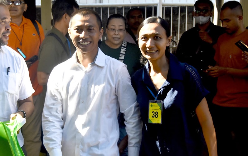 Nyoman Sukena tersenyum bersama istrinya usai sidang.