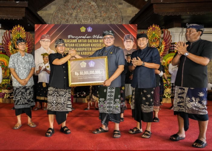 HIBAH: Bupati Giri Prasta saat menyerahkan Bantuan Hibah dan BKK di Gedung Balai Budaya Gianyar, Minggu (22/9).