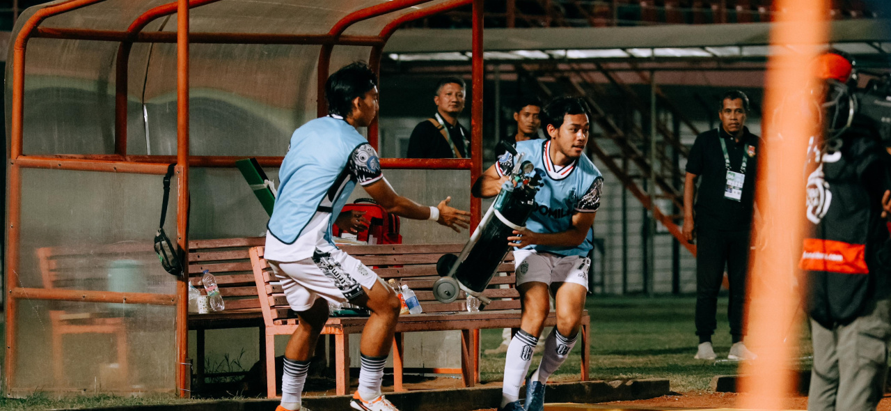 Dari bangku cadangan, Luthfi Kamal dan Komang Tri bergegas berlari membawa tabung oksigen menuju lapangan