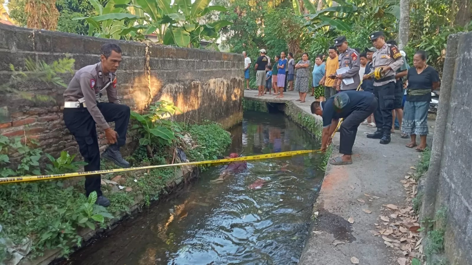 OLAH TKP: Polisi melakukan olah TKP tempat penemuan sosok pria asal Kubutambahan, Buleleng, yang terbujur kaku di saluran air. (Polres Buleleng)