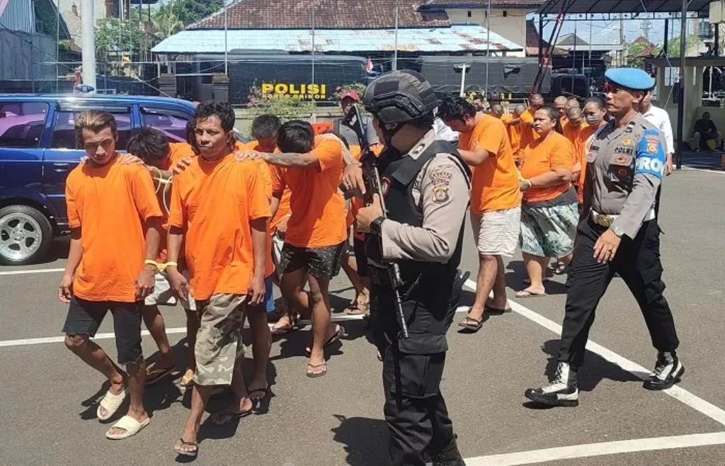 Pelaku pelemparan laundry pakai Bom Molotov, Adhitya Delvansha Snae, 27, dan Roman Delvansha Snae, 20, dikawal polisi bersama tahanan yang lainnya. (Foto Andrian Suwanto.)