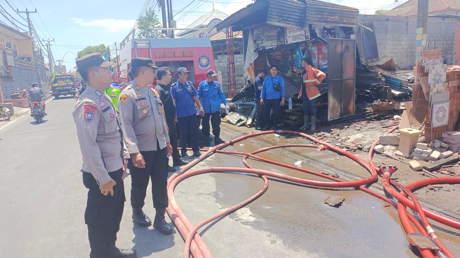 Petugas pemadam kebakaran sedang memadamkan api pada peristiwa Kebakaran yang melanda sebuah toko bangunan di Buleleng