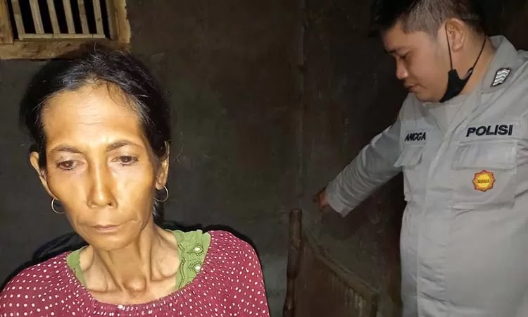 Supiani (kiri) saat menunjukkan alu penumbuk kopi yang digunakan untuk menghabisi suaminya sendiri pada polisi.