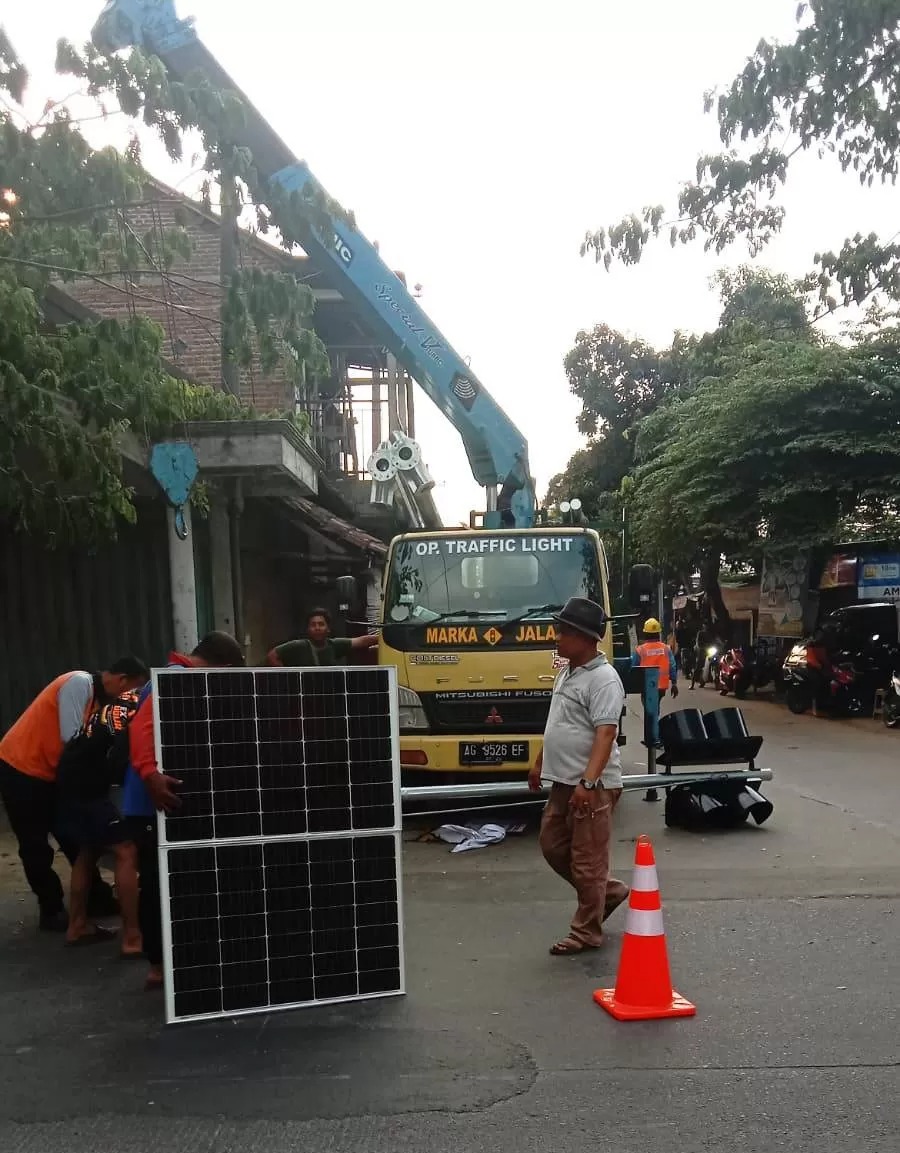 TERSENGAT LISTRIK: Petugas mengamankan peralatan rambu flasher yang mengakibatkan tiga petugas tersengat listrik dan satu tewas di tempat.