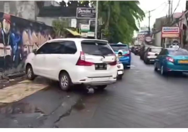 Sejumlah mobil parkir dengan makan badan jalan dan trotoar di Kuta