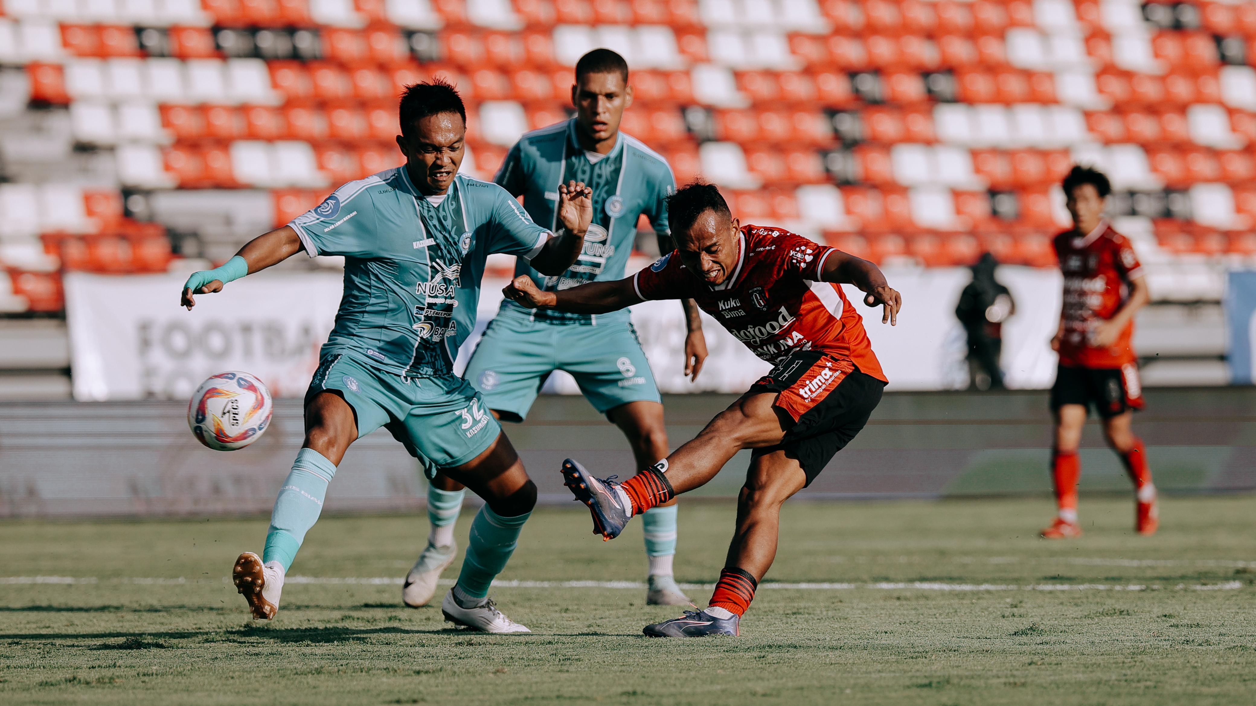 Winger Bali United, Irfan Jaya (merah) melepaskan tembakan ke gawang PSBS Biak di pekan ke-10 Liga 1 2024/2025. Di laga ini, Bali United kalah dengan skor 2-0 di Stadion Kapten I Wayan Dipta, Gianyar